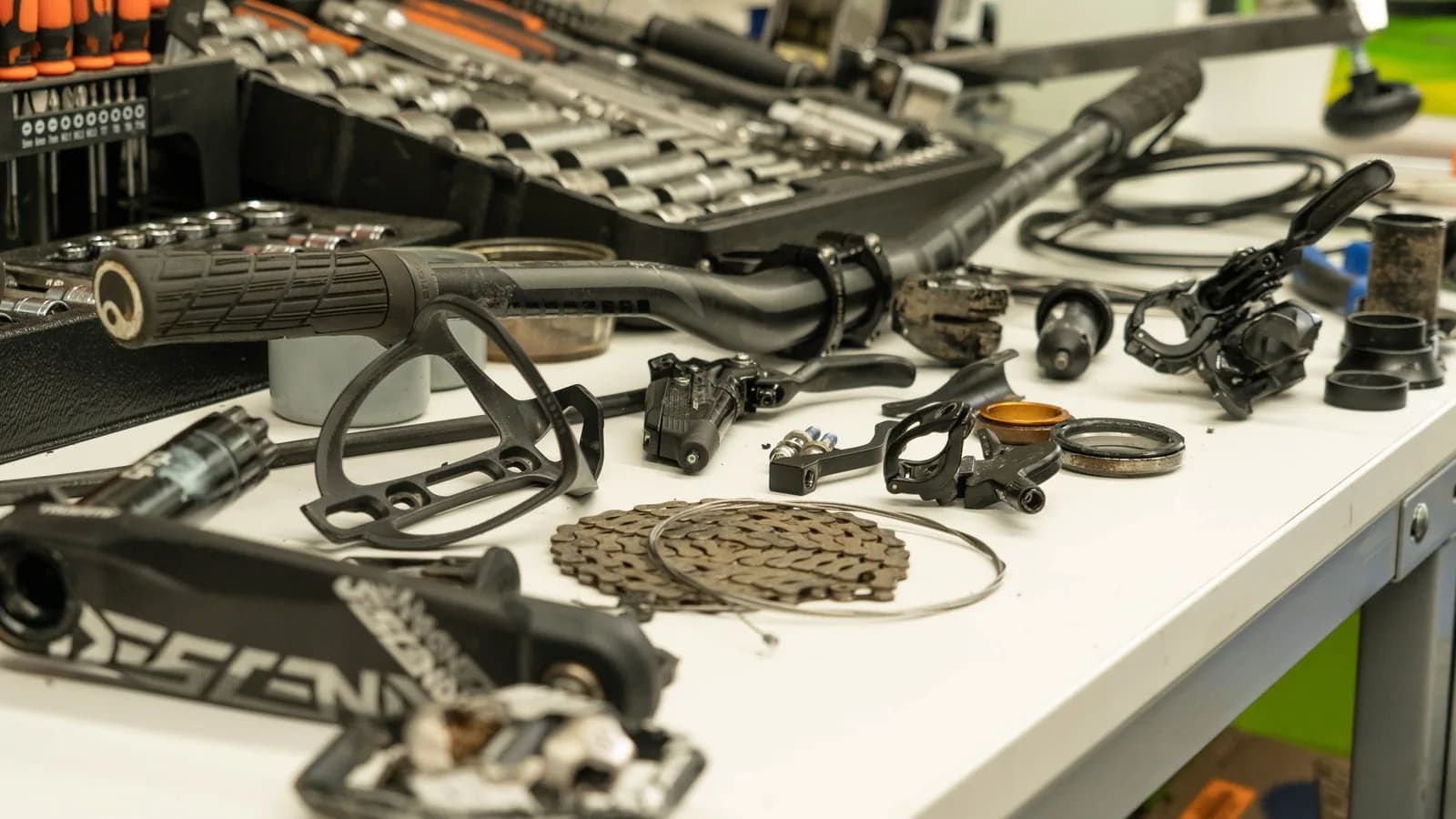 Bicycle components and tools arranged across a workshop bench